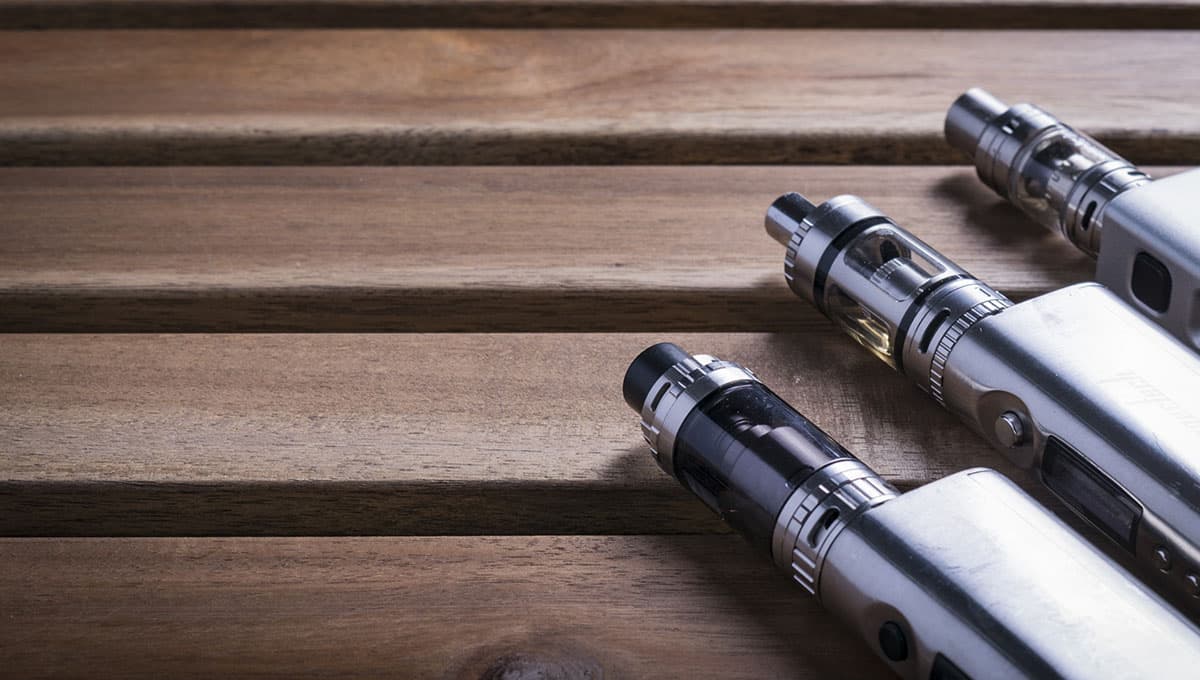 a group of vaping devices on a wooden surface