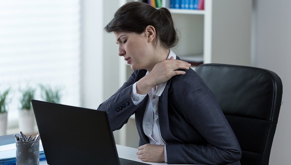 a woman holding her shoulder